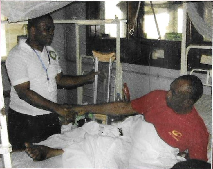 A KUTH volunteer greeting a hospital patient at his bedside during the Foundation's 2012 medical outreach in Lagos.