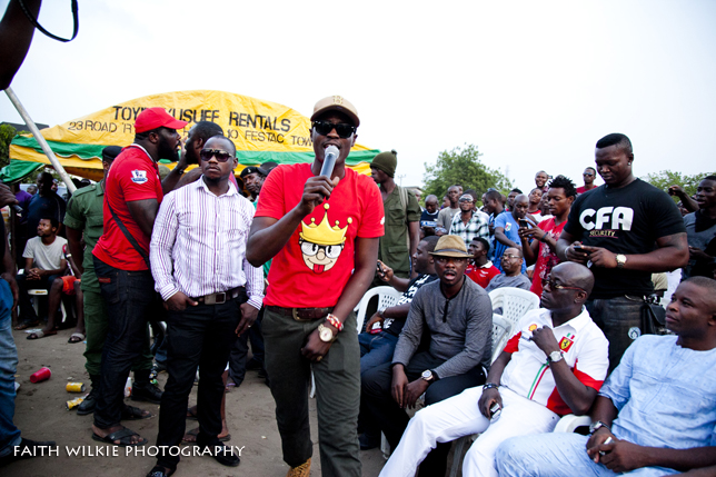 Artiste performing to crowd with dignitaries seated
