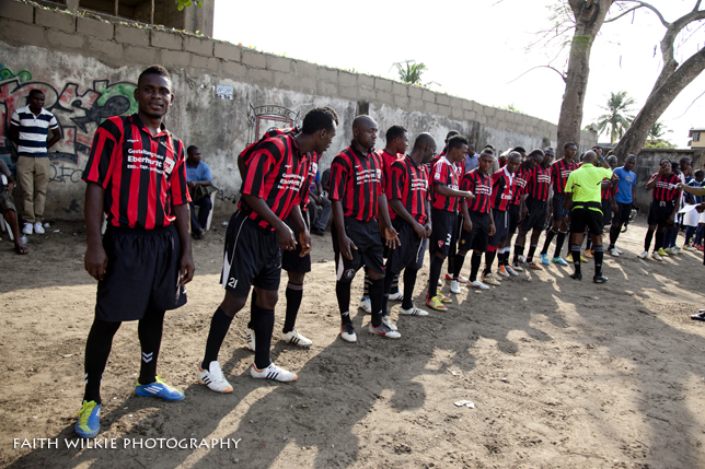 Red and black striped team walking onto pitch