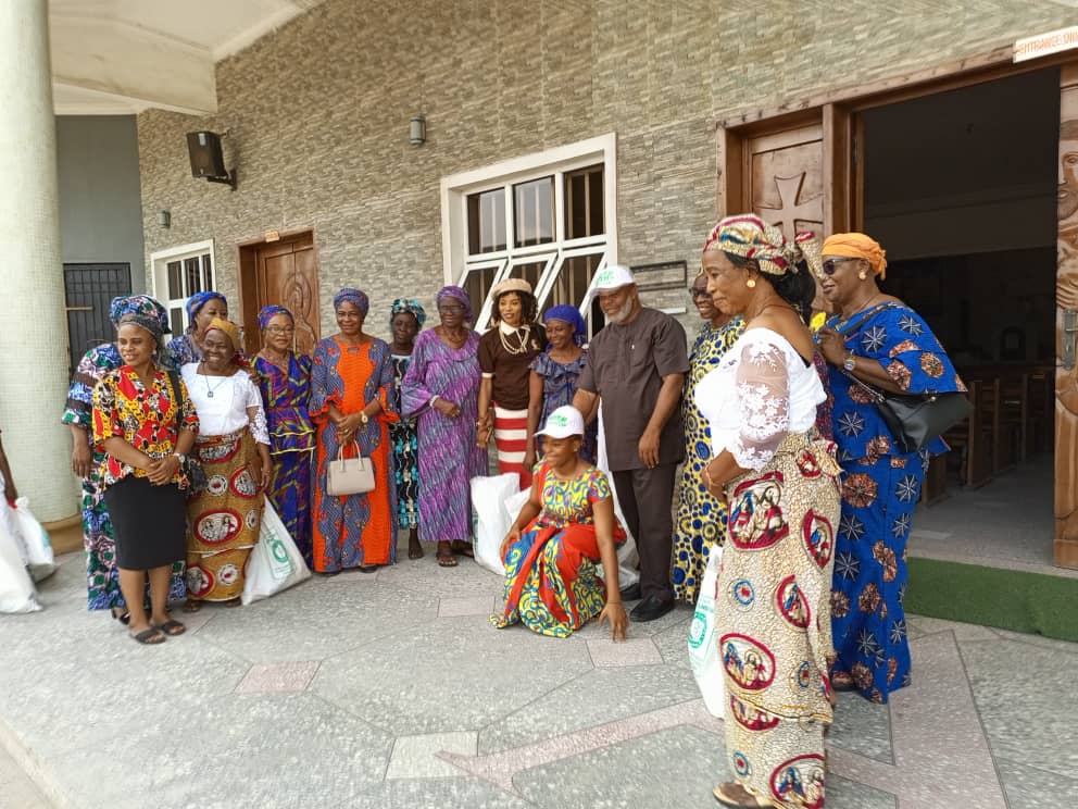 Large group of widows and KUTH Foundation team in church courtyard